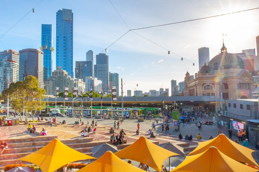 Federation square on a sunny day overlooking Flinders Station and the city skyline