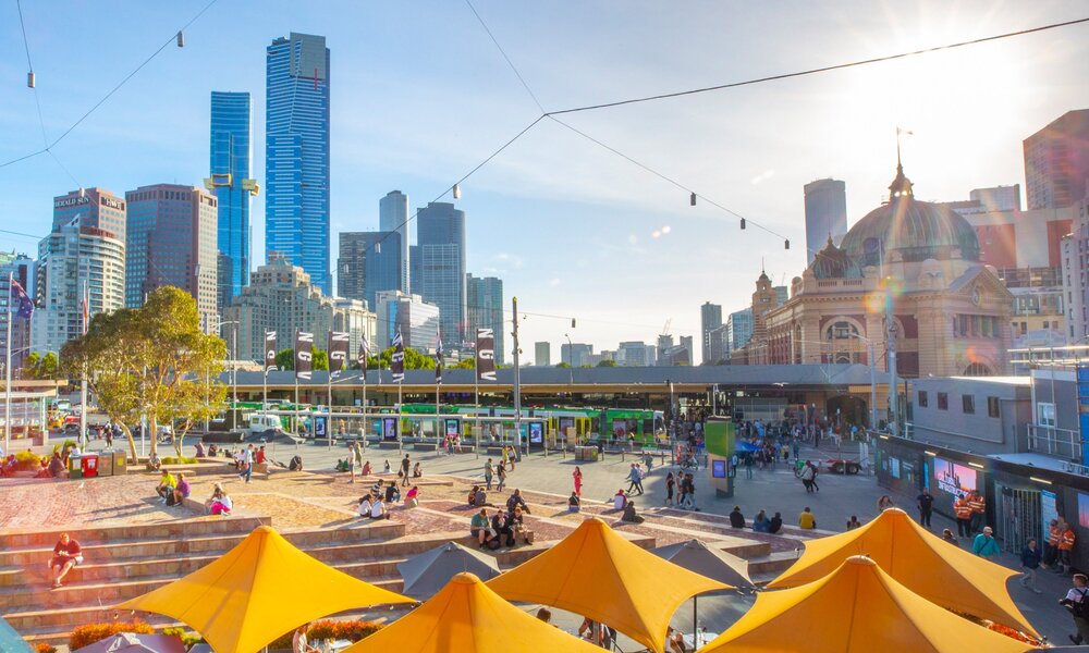 Federation square on a sunny day overlooking Flinders Station and the city skyline