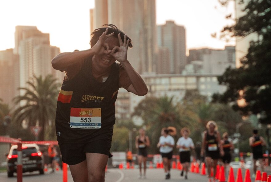 Runners on a road with city buildings in the background. 