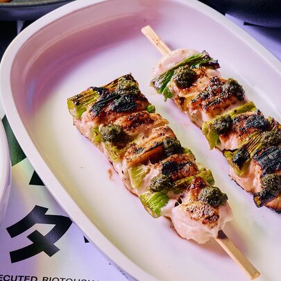 Two chicken skewers on a plate.