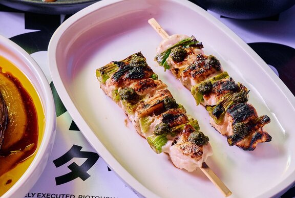 Two chicken skewers on a plate.