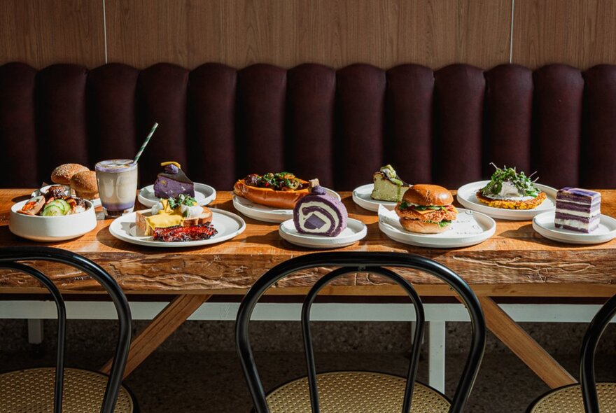 Long table in a restaurant setting with a variety of sweet and savoury dishes.