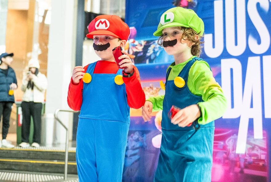 Two kids dressed as Mario and Luigi from the Super Mario Brothers.