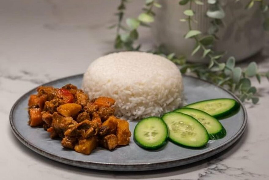 A Filipino dish with meat, moulded rice and slices of cucumber. 