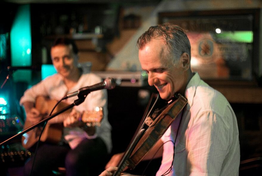 A violin player and a guitarist playing live music at P.J.O'Briens pub.