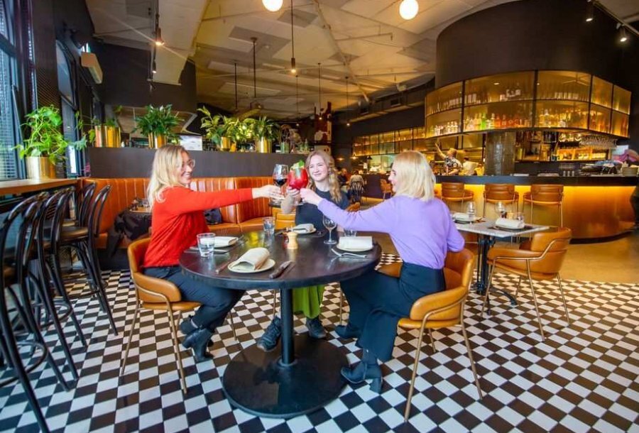 Three women saying cheers at a table