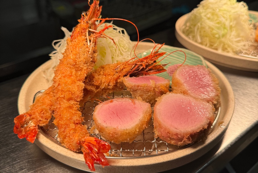 Crumbed prawns and katsu on a plate.
