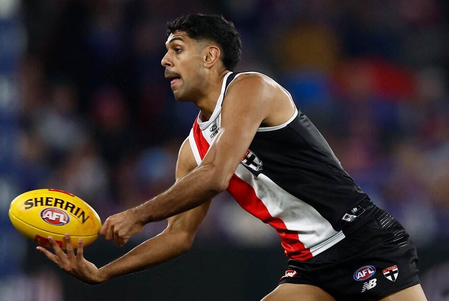 St Kilda AFL football player with the ball during a match.
