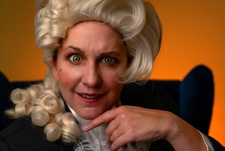 A woman dressed up in a powdered wig looking intently. 