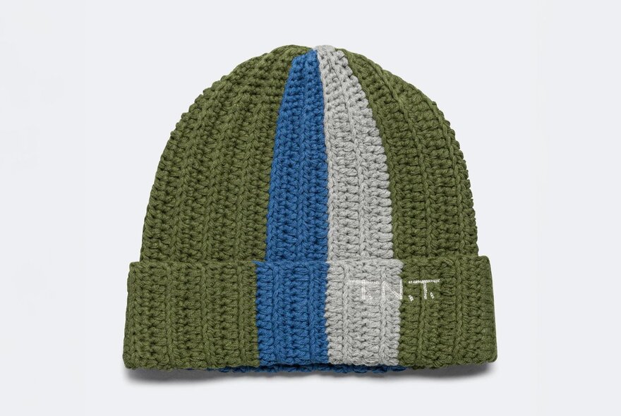 A crocheted beanie with green, blue and grey stripes, and a logo that reads T.N.T.
