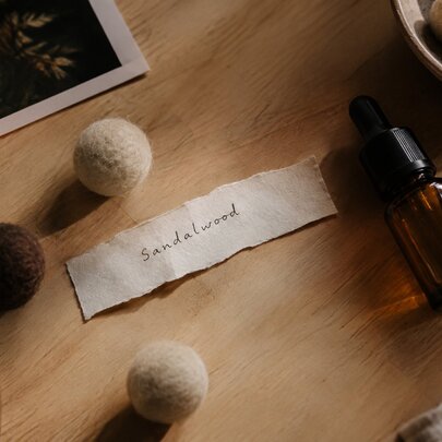 Wooden scent balls next to a glass vial labelled sandalwood.