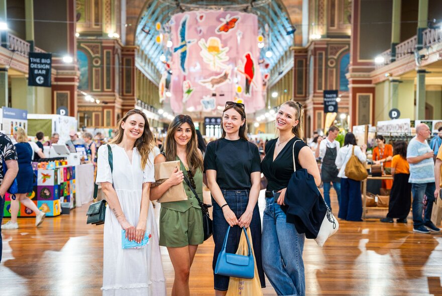 A group of four friends posing for a photo at a designer craft market inside the Royal Exhibition Building.