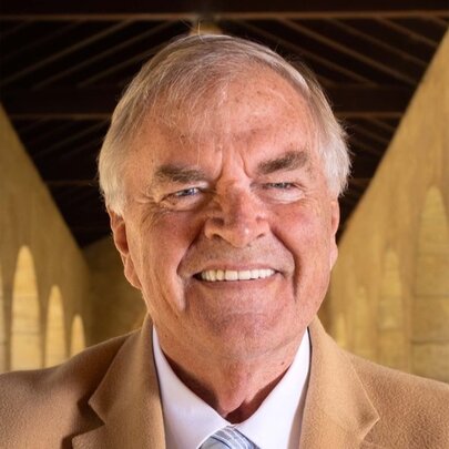 Smiling Kim Beazley wearing camel-coloured jacket and shirt with tie.