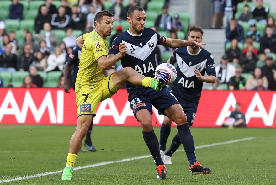 Soccer players with the ball during a game.