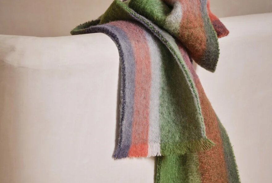 A multicoloured scarf hanging over the side of a banister.