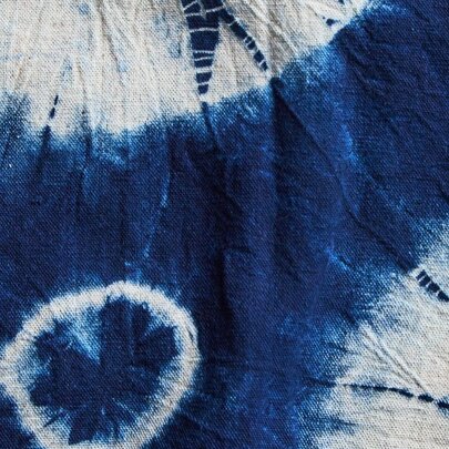 A close up photograph of an indigo and white tie-died fabric.