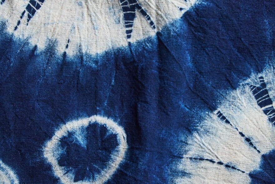 A close up photograph of an indigo and white tie-died fabric.
