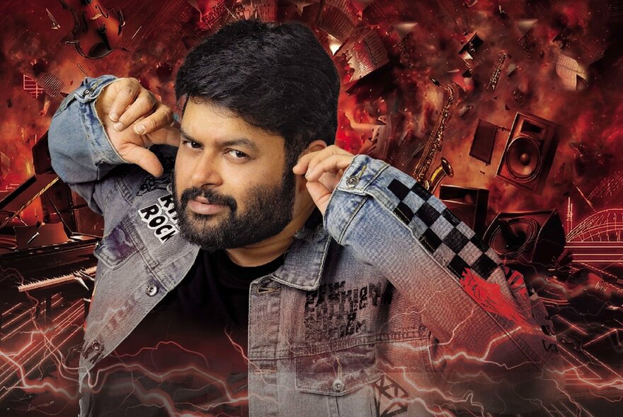 Man wearing a denim jacket, his fingers in this ears, chaotic images in the background.