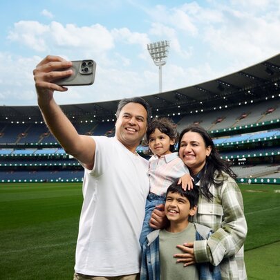 A family taking a selfie while standing on the ground at the MCG.
