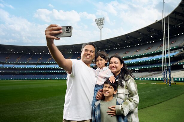 A family taking a selfie while standing on the ground at the MCG.