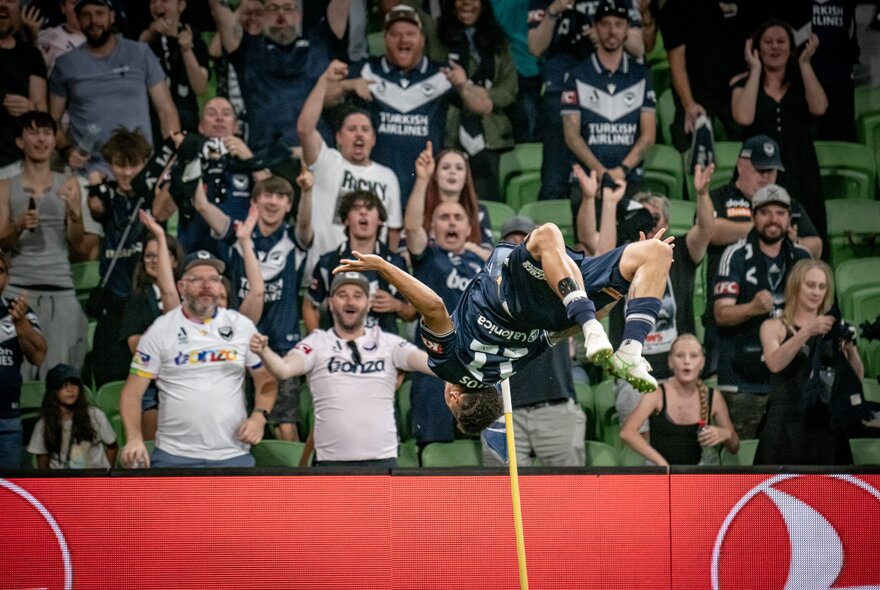 Football fans in a crowded soccer stadium.