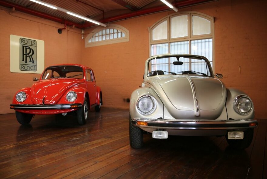 Red and a gold classic Volkswagen beetles.