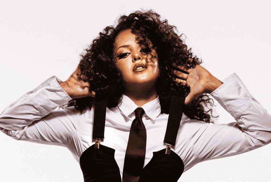 Torres Strait Islander singer Zipporah wearing a white shirt and a black vest with braces.