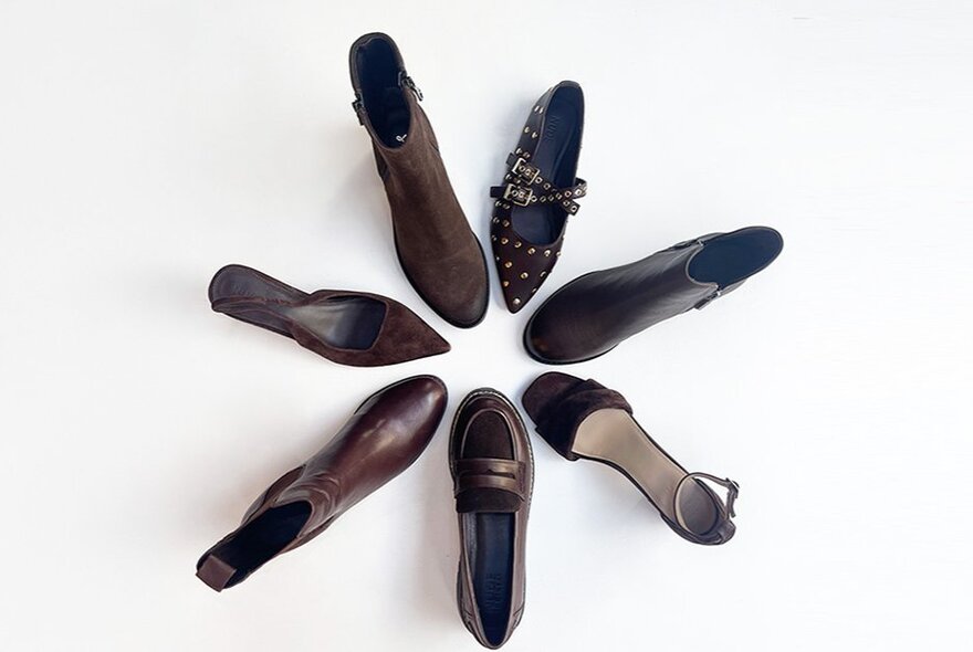 Looking down of six different shoes arranged in a star pattern.
