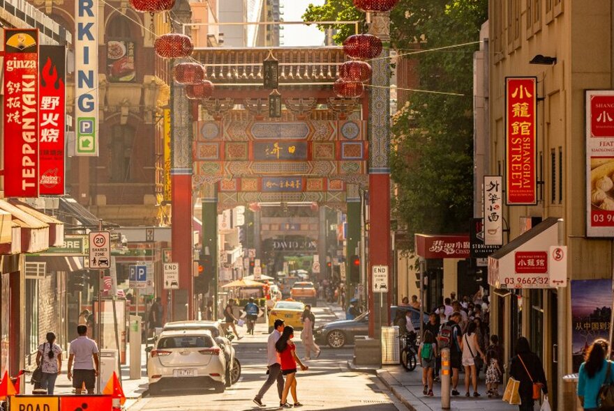 A busy Chinatown street with lanterns and restaurant signs. 