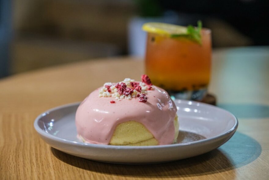 Soufflé pancakes on a grey plate topped with strawberry custard.