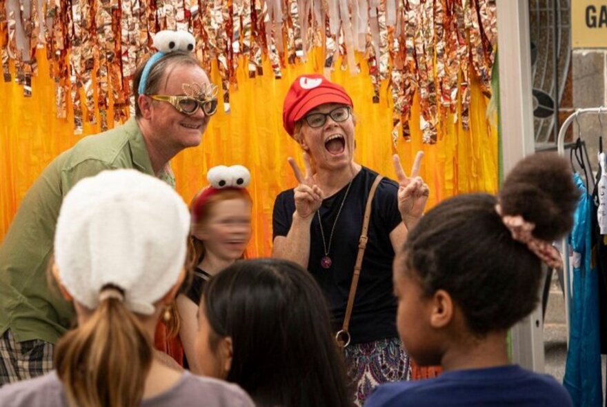 People having fun at a festival wearing funny headgear with googly eyes.