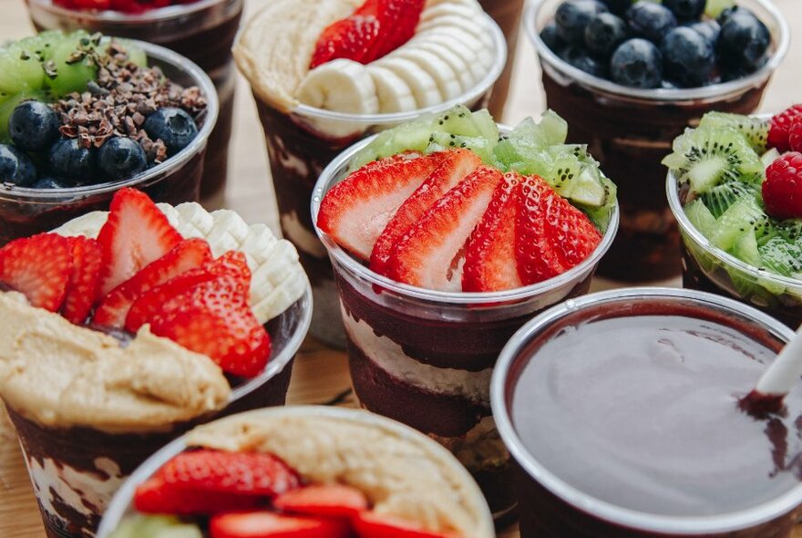 Close up of plastic containers of fruit including strawberries and blueberries.