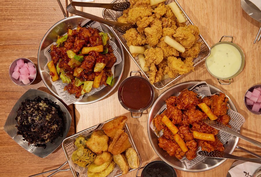 A restaurant table full of fried chicken and other Korean dishes.