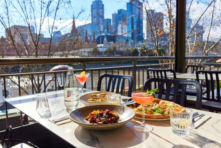 Food and cocktails on a table with a view in the background