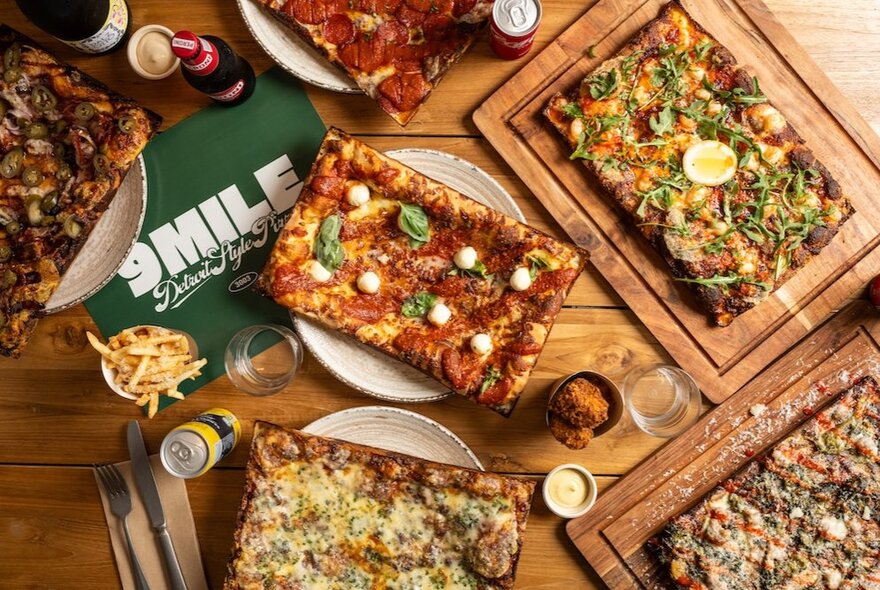 Rectangular pizzas on wooden platters.