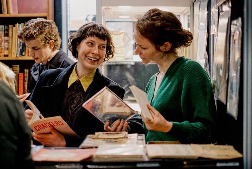People holding books and interacting with each other at the Rare Book Fair.