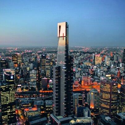 A panoramic dusk view of the Melbourne skyline featuring the Eureka Tower in the centre foreground.