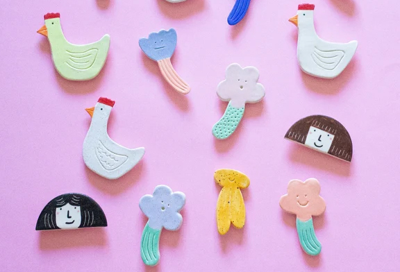 A set of magnets shaped like ducks, flowers and faces.