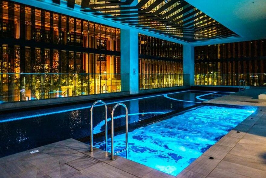 A hotel pool at night, with blue lighting