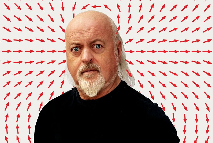 Head and shoulders of the UK comedian Bill Bailey, staring intensely at the viewer, standing against a background of multiple small red arrows all pointing towards or coming out of his head.