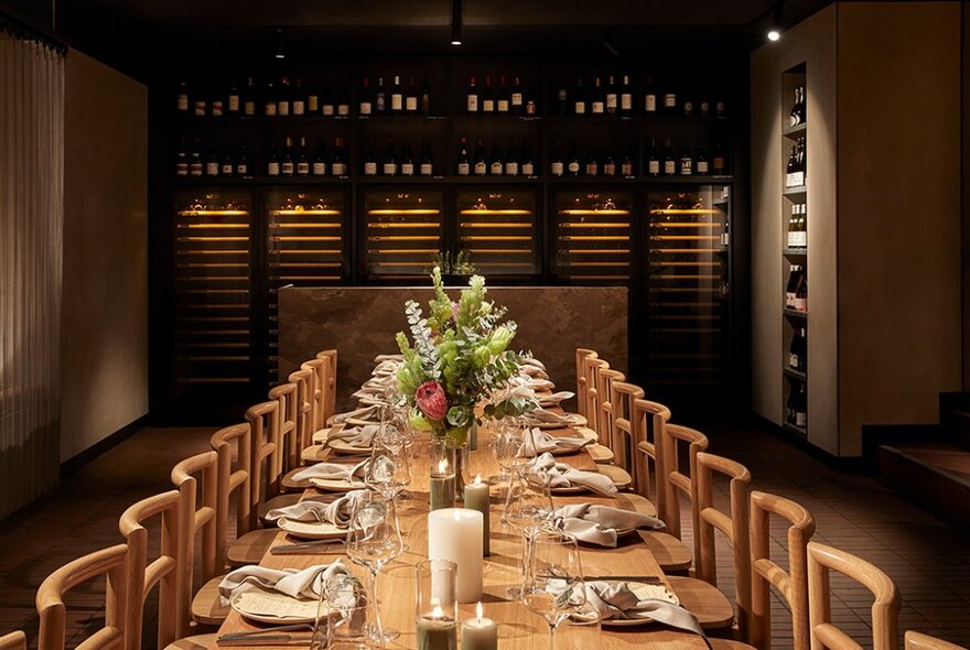 A long dining table in a private room at Aru restaurant set for a dinner service .