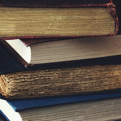 A stack of four vintage books.