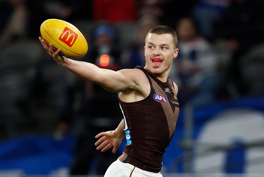 Hawthorn AFL football player with the ball during a match.