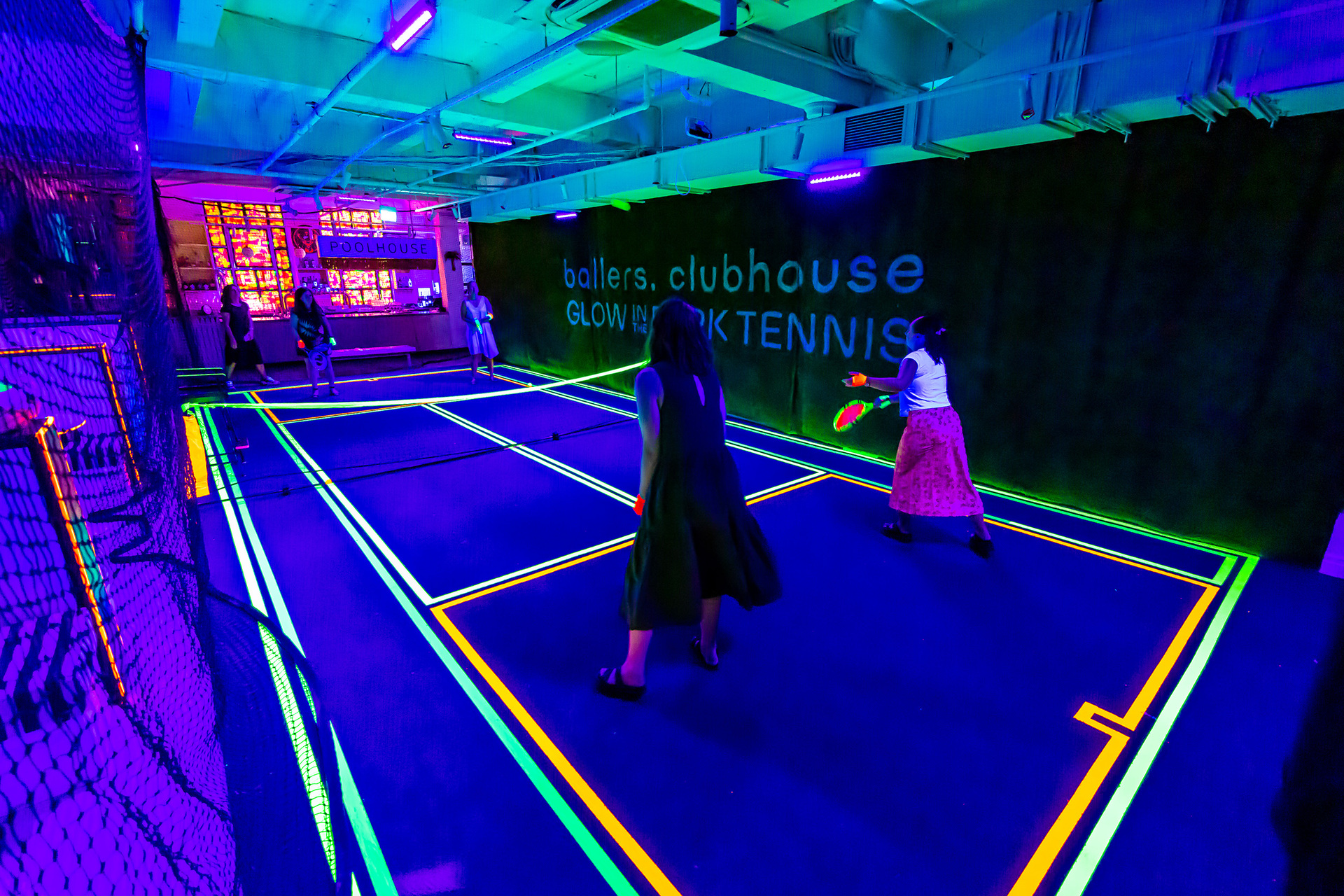 Two people are playing glow in the dark tennis