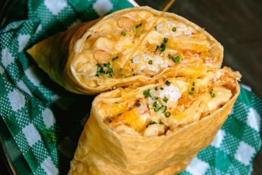 A lasagne pocket cut it two to reveal a pumpkin mixture, balanaved on a green and white gingham cloth. 