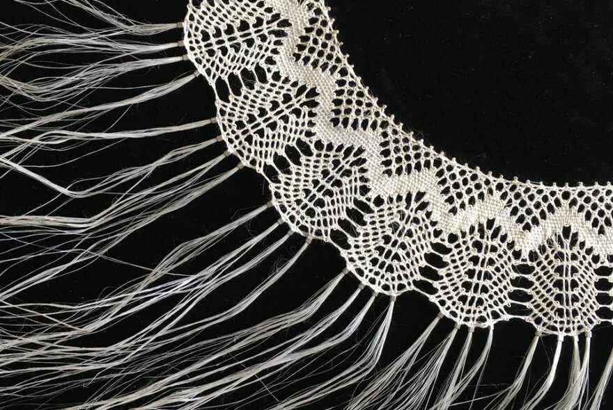 A lace collar in the making, with strands visible. 