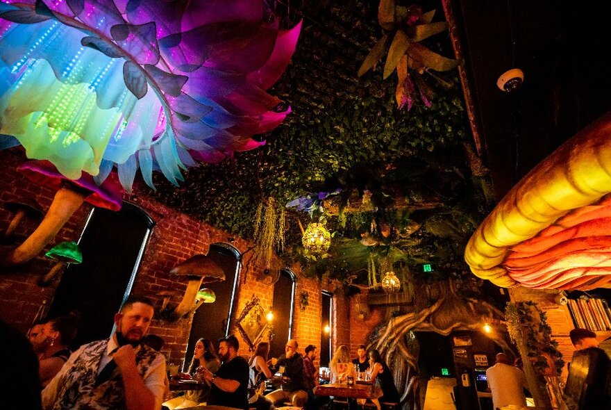 Psychedelic lighting and decor in a lamplit cellar bar.