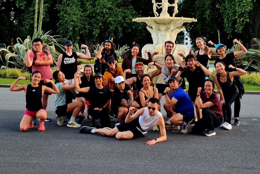 A large group of runners posing for a photograph in front of the fountain in Carlton Gardens.