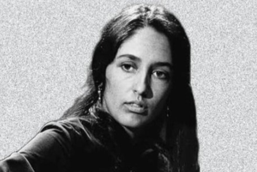 Sixties singer Joan Baez, with long dark hair and earrings.
