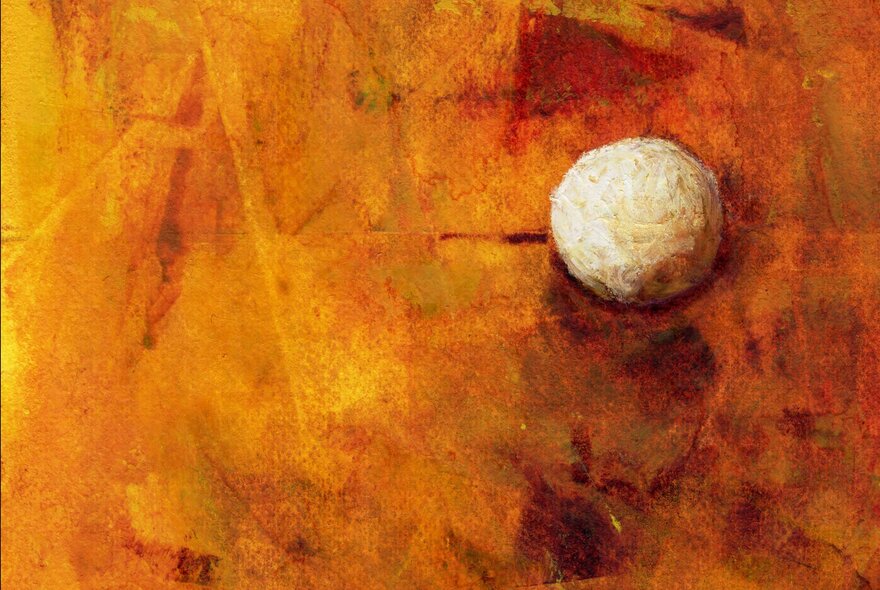 Artwork showing orange and yellow tones of abstract paint with a small white ball lodged into the painting. 